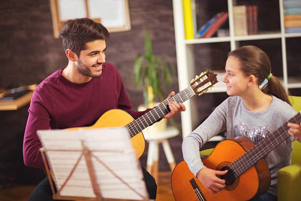 Guitar Teacher Teaching The Little Girl